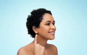 african american woman with bare shoulders showing her ear