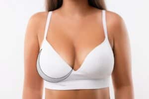 Woman in white bra with breast asymmetry