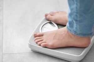 A close-up shot of a woman standing on a scale