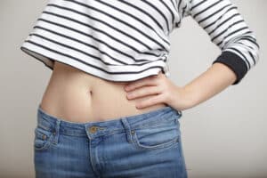 Image of woman’s flat tummy after recovery from tummy tuck surgery.