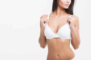 Woman in bra with natural looking breasts after breast implant removal and breast lift