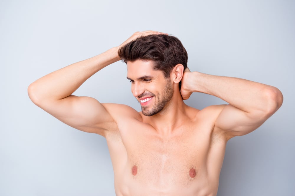 Shirtless man looking confident after inverted nipple repair surgery.