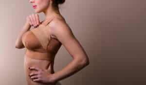 Woman wearing compression bra after cosmetic breast surgery to help with swelling