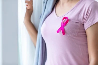 Woman in tshirt wearing pink ribbon for breast cancer