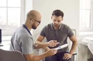 Male patient discussing inverted nipple repair with a doctor during a consultation.