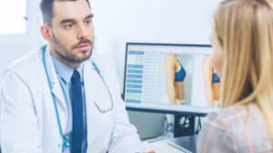 Surgeon meeting with woman to discuss revision cosmetic surgery